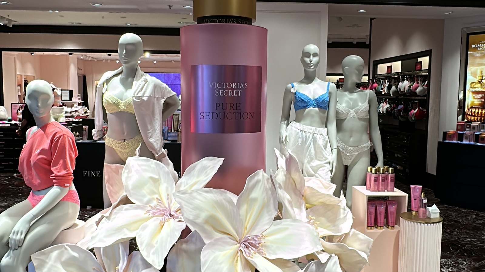 Victoria’s Secret vitrin dekoru — dev parfüm maketi ve çiçek düzenlemesi
